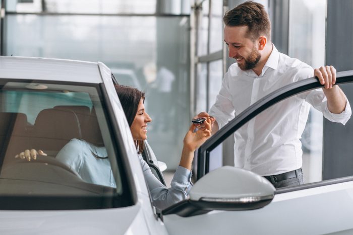 salesman woman looking car car showroom
