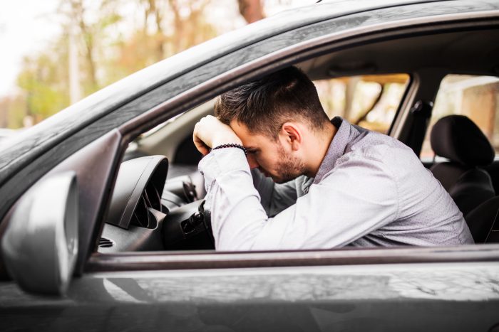 young man sitting car very upset stressed after hard failure moving traffic jam