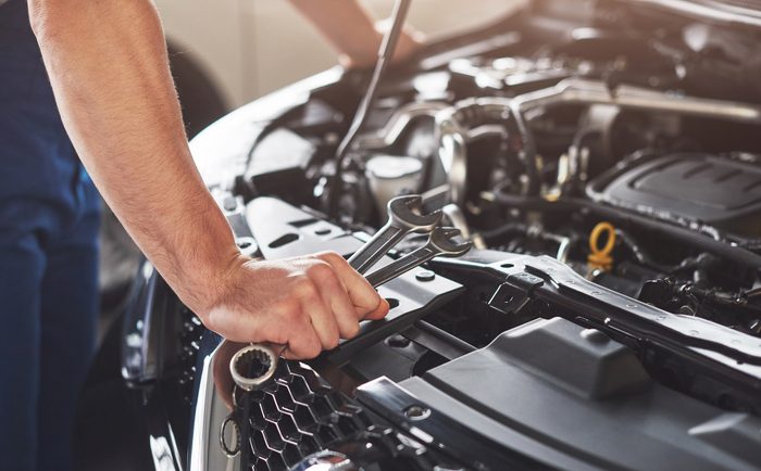 Noleggio auto usate senza anticipo: come funziona e a chi conviene muscular car service worker repairing vehicle