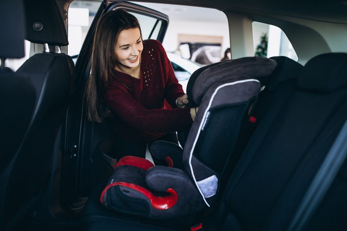 Seggiolini e trasporto bambini in auto: regole e consigli 2026 woman installing safety car sit into car 1