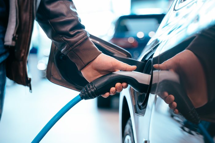 Auto elettriche a noleggio a lungo termine: convengono? human hand is holding electric car charging connect electric car