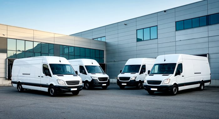 white delivery vans parked outside warehouse